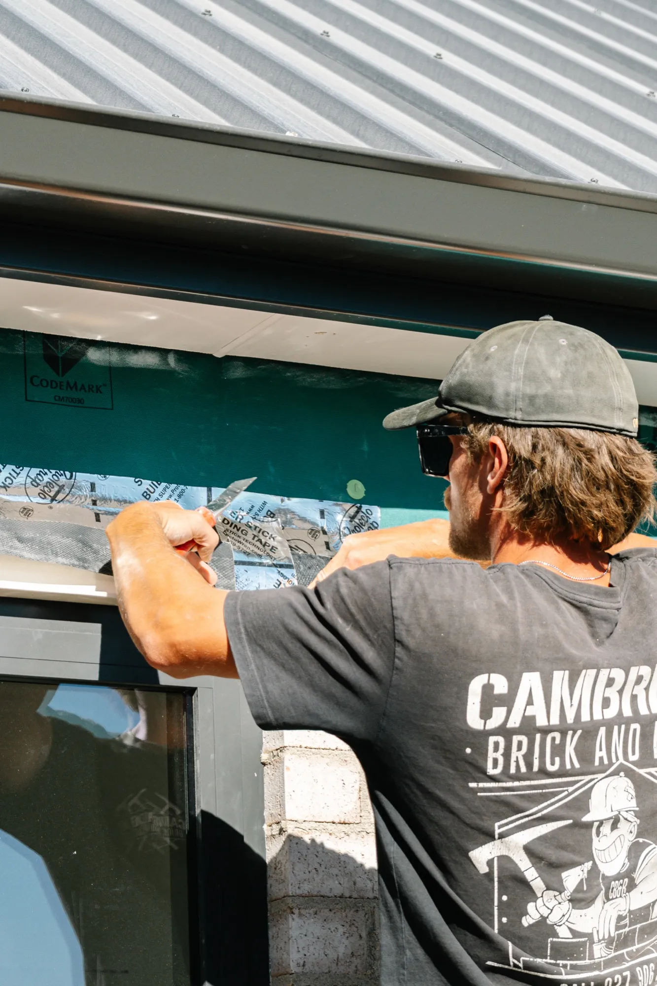 A Cambridge Brick and Block bricklayer finishing the top course under the eaves