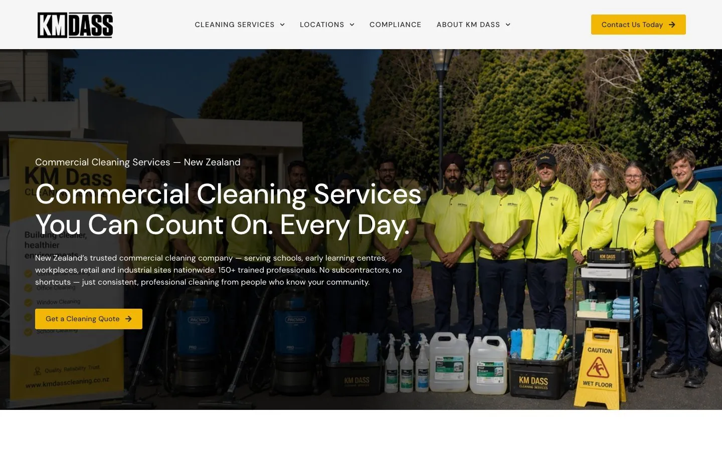 The KM Dass Cleaning homepage with the team in uniform beside their cleaning equipment