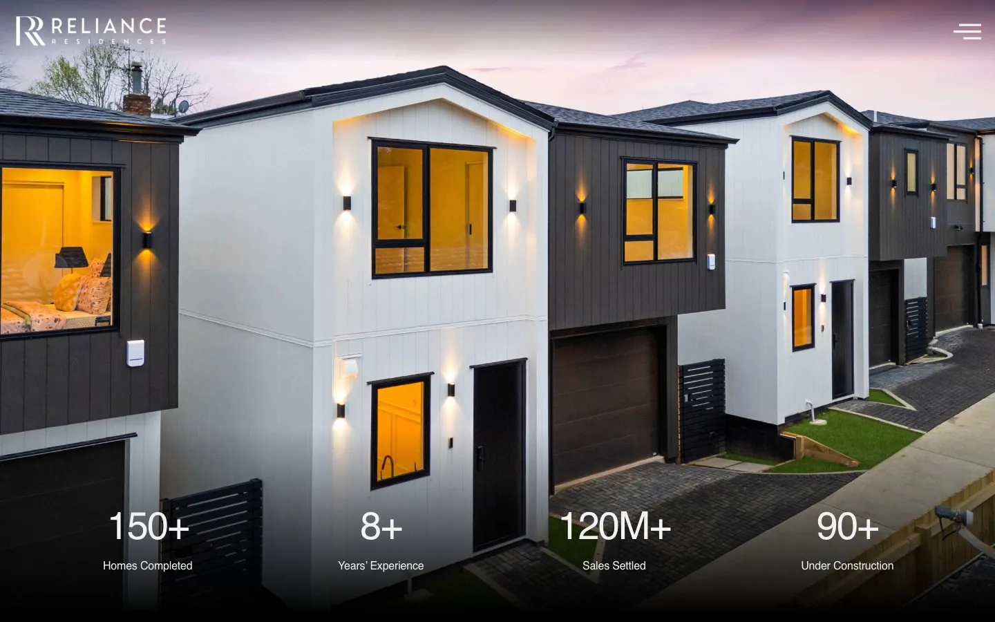 The Reliance Residences homepage with a twilight townhouse and the track record stats