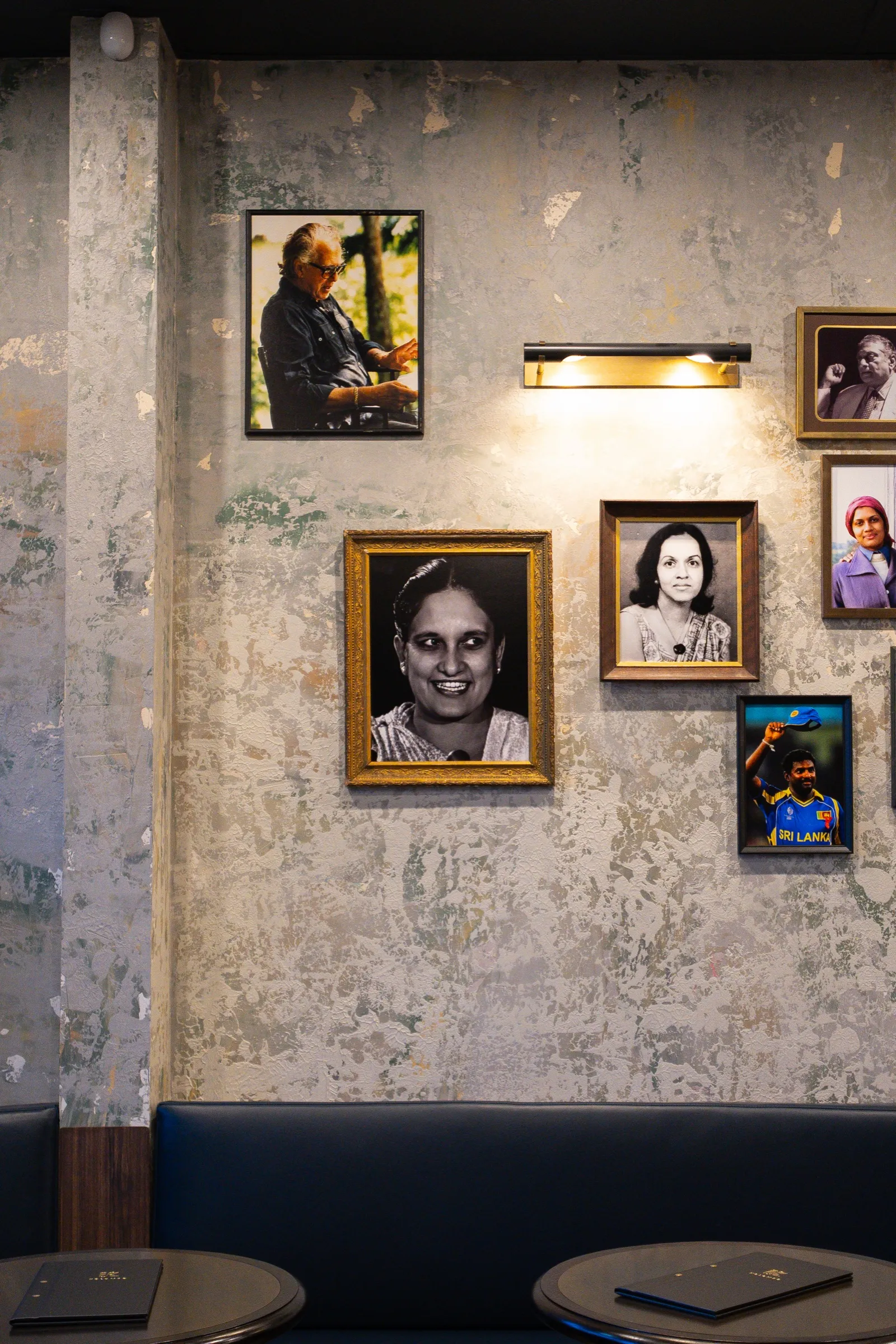 Framed family portraits on a textured wall above the booth seating