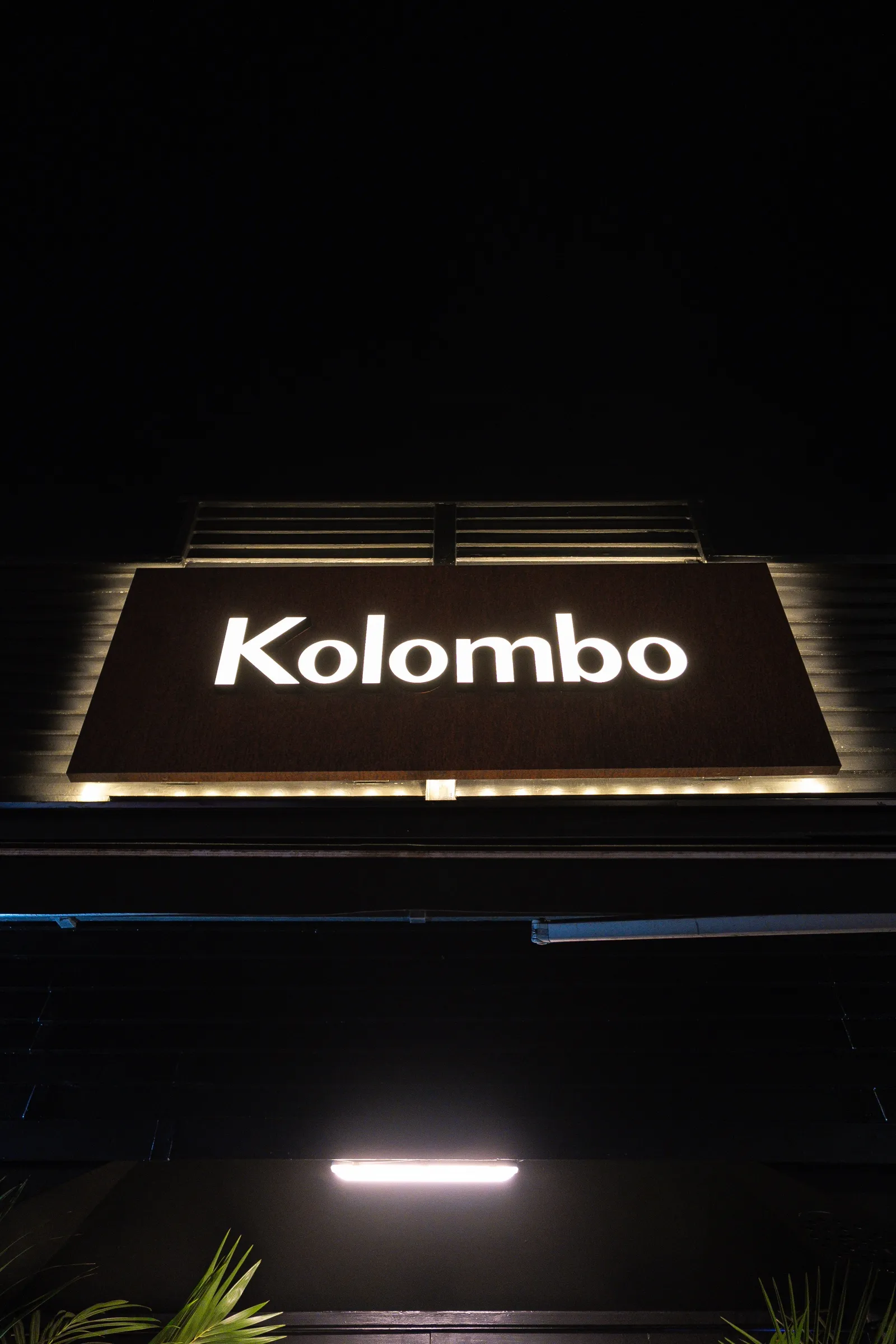 The lit Kolombo sign at night