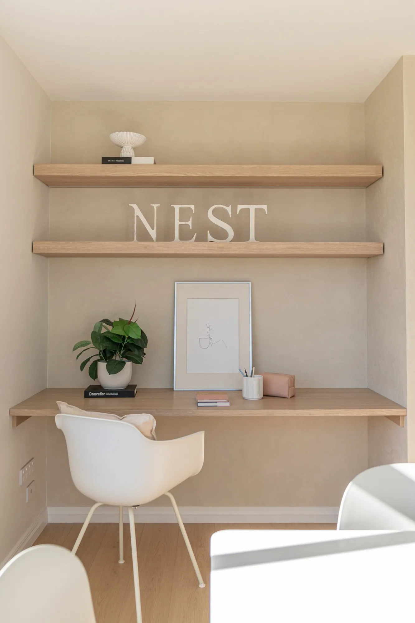 A study nook with timber shelves against a warm Venetian plaster wall