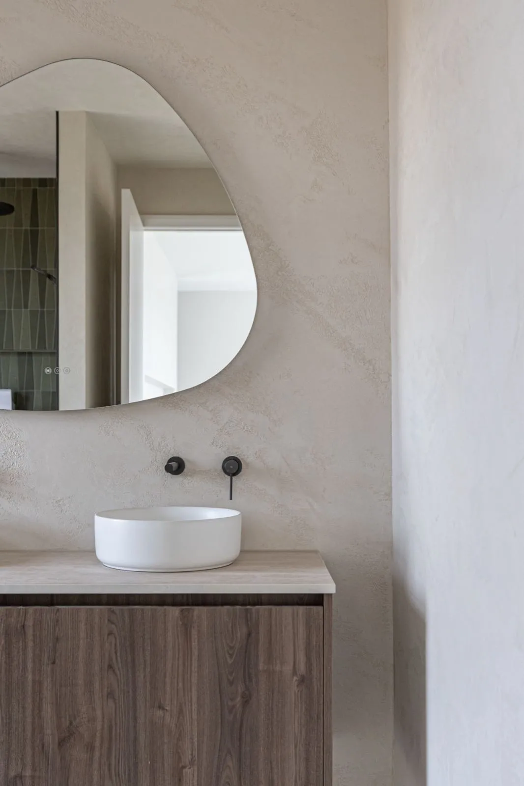 Vada Interiors bathroom with a pebble mirror and vessel basin