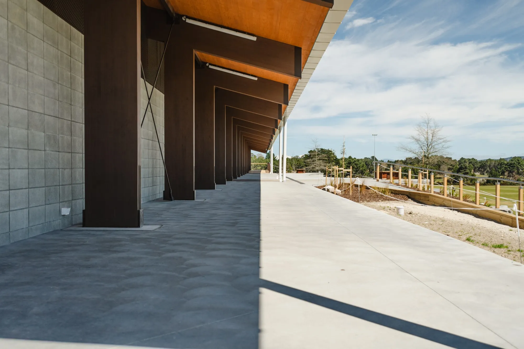A covered concrete walkway along the pavilion